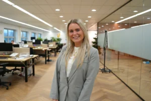 Eline Boon 1 Eline Boon op de vloer op het kantoor van Salesrecruiters Zoetermeer in een grijs pak.