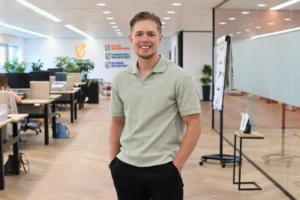 Joran Berkhout 19 Joran Berkhout: man staat lachend in het midden van een kantoor